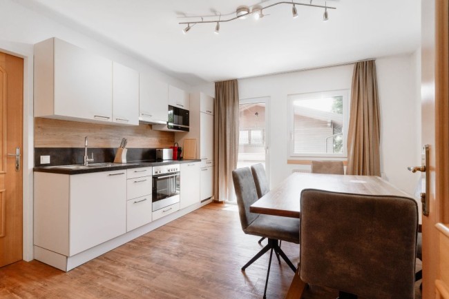 K&uuml;che mit gro&szlig;em Esstisch und Balkon