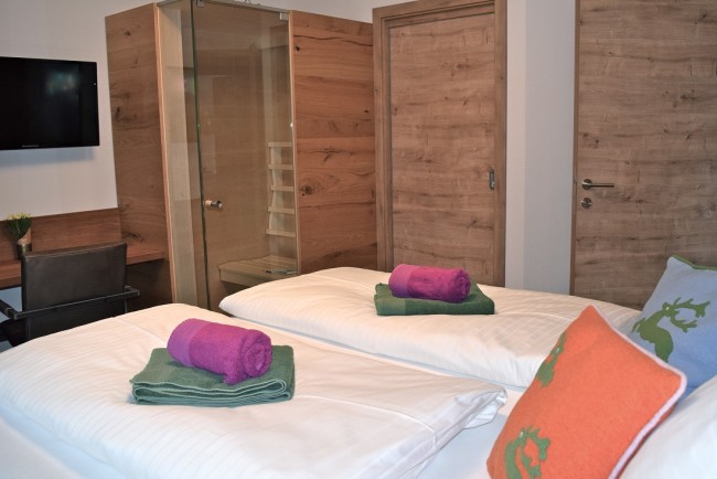 Schlafzimmer mit Flat-TV und Infrarotkabine im Appartement Mountain Room