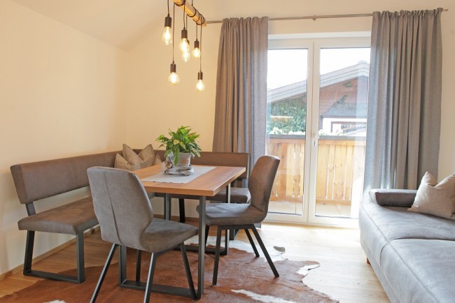 Wohnzimmer mit Esstisch und Balkon im Appartement Sky Lodge