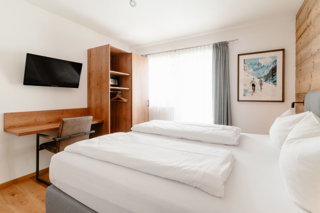 Schlafzimmer mit Flat-TV und Balkon